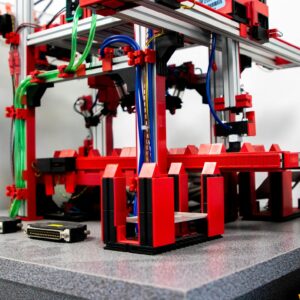 Close-up view of a robotic assembly machine with vibrant red and metallic components.